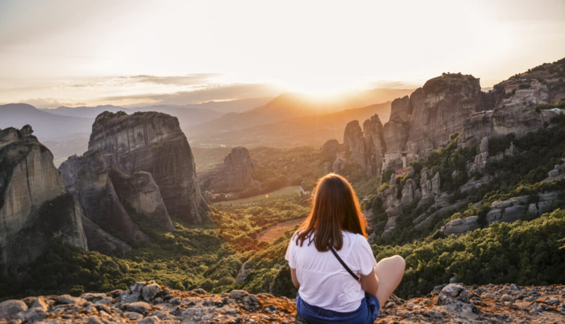 girl watching the sunset in Meteora Greece