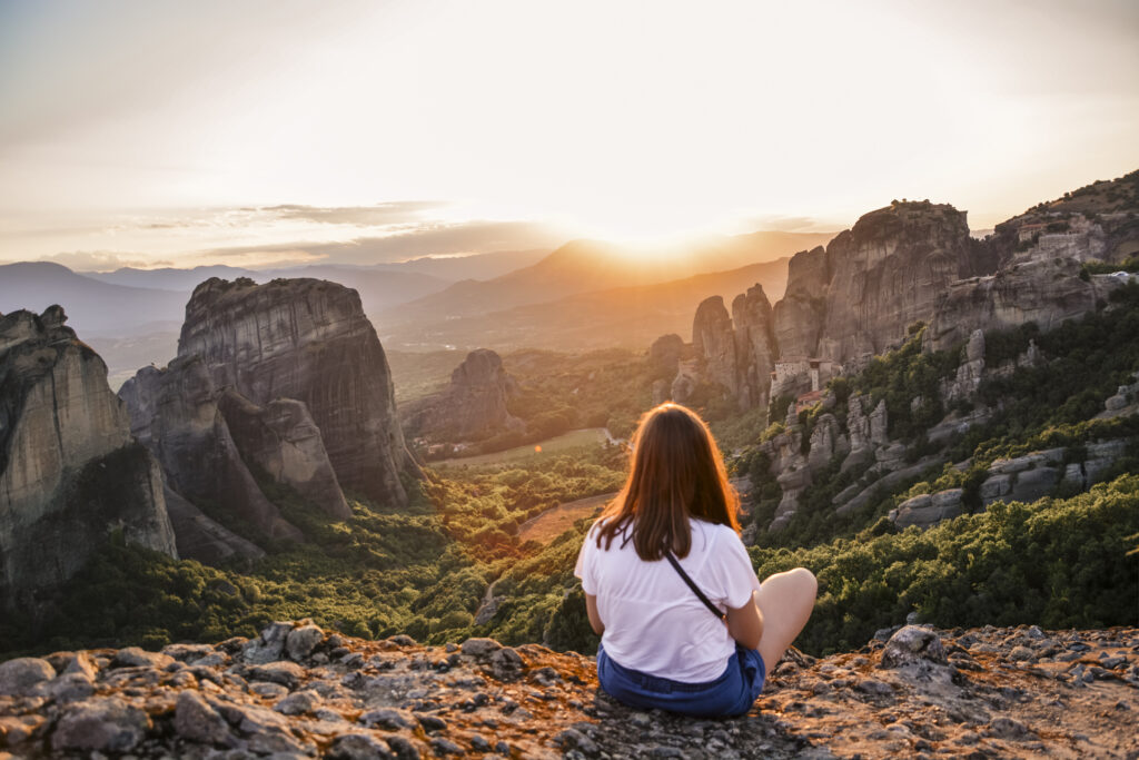 girl watching the sunset in Meteora Greece