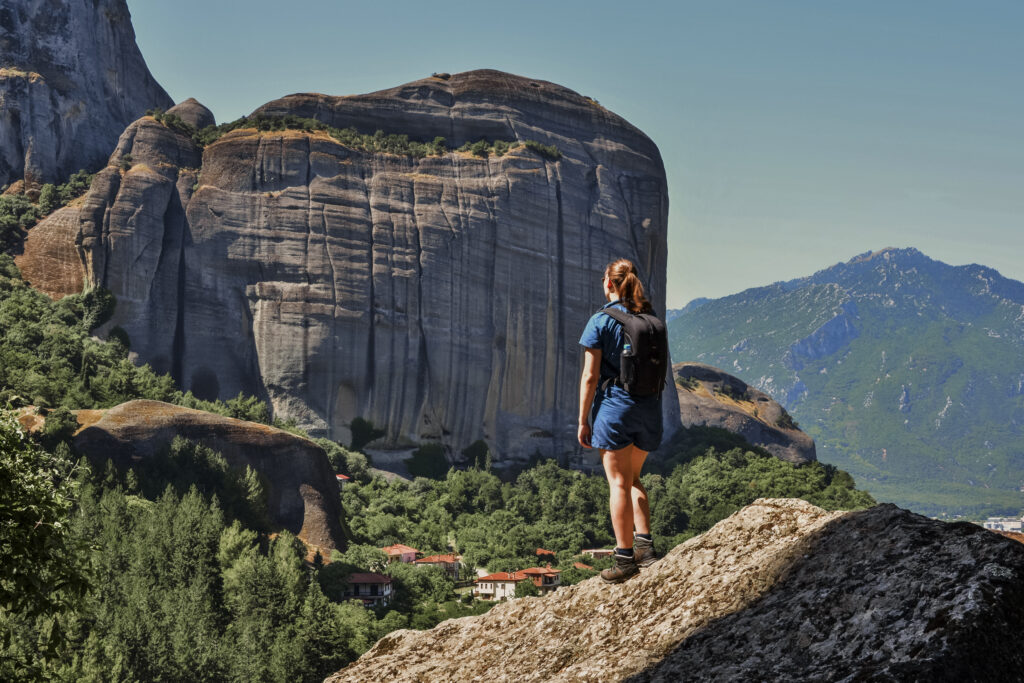 girl standing on rock, taking in the view on the Holy Spirit hike in Meteora, Greece