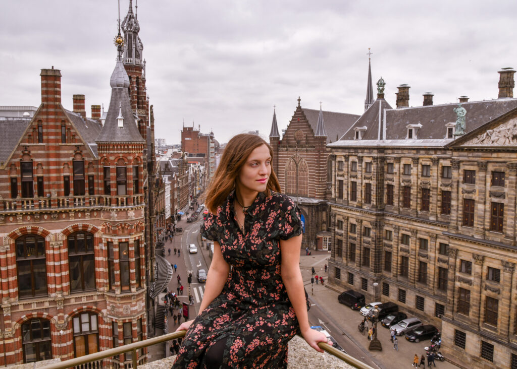 Girl sitting on edge of balcony of W hotel in Amsterdam. 