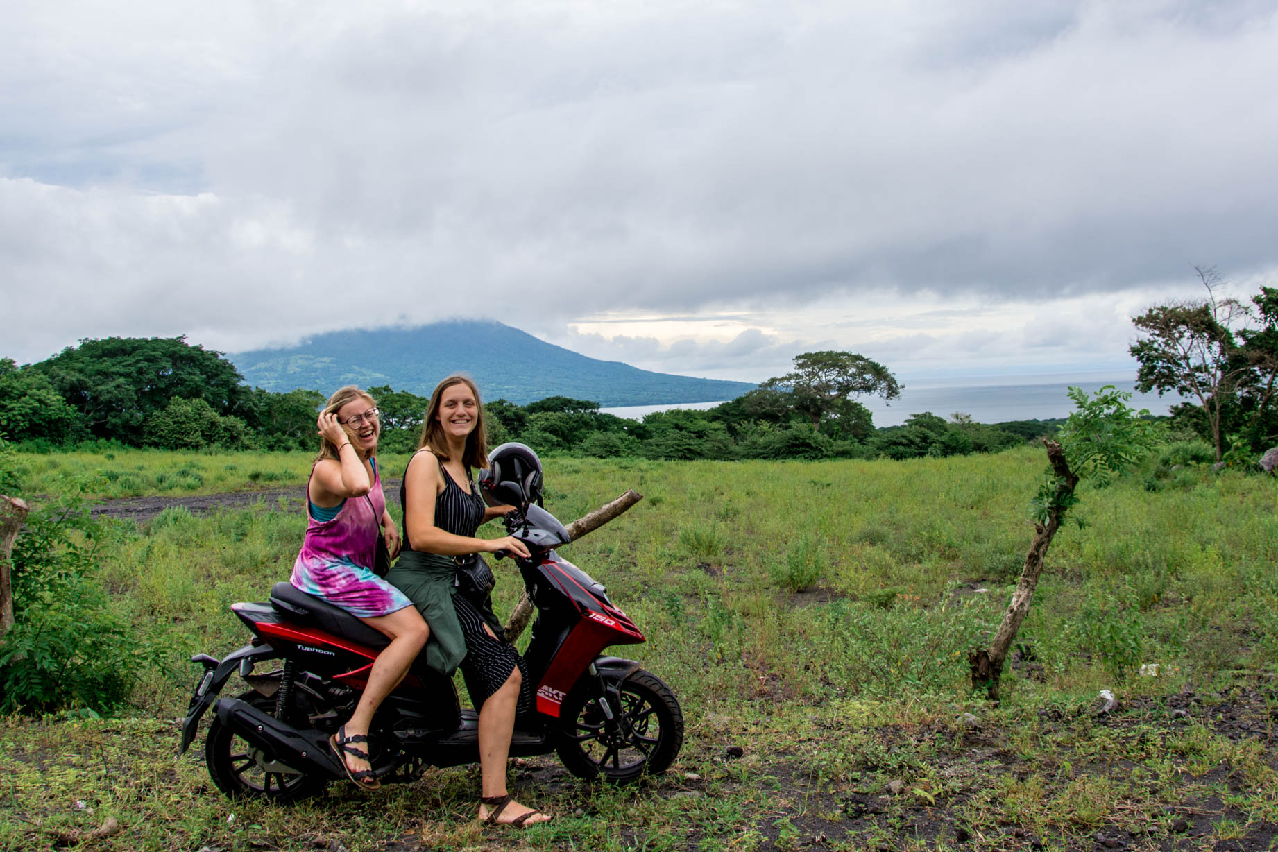 Two girls on scooter in ometepe Nicaragua with volcano in the Background