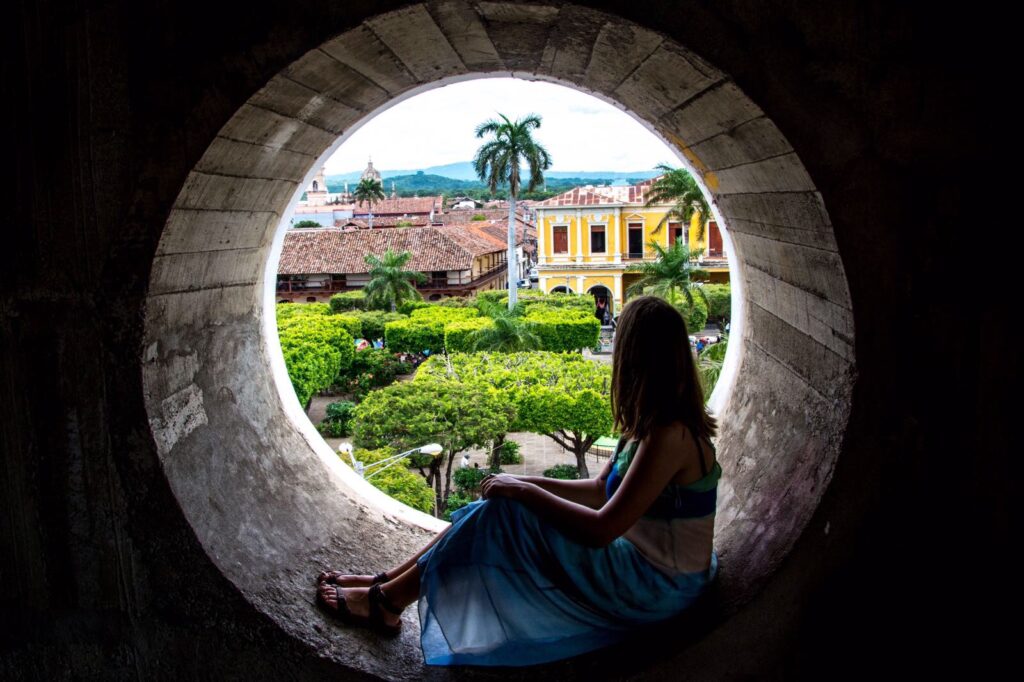 Girl sitting in window of Our Lady of the Assumption Cathedral Granada, Nicaragua