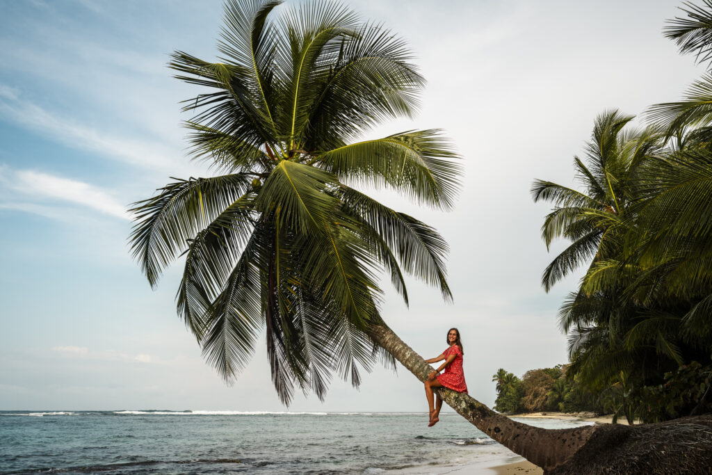 girl on palm tree on a beach on bastimentos island in Bocas del Toro 