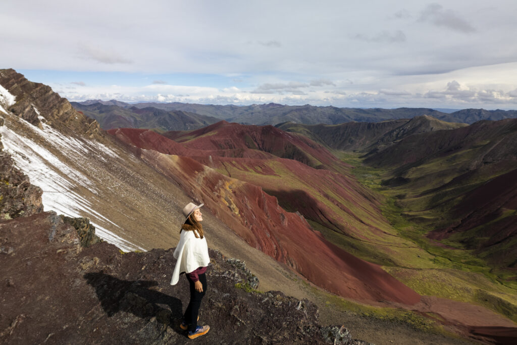 girl enjoying the sun on top of viewpoint of the red valley, Peru 