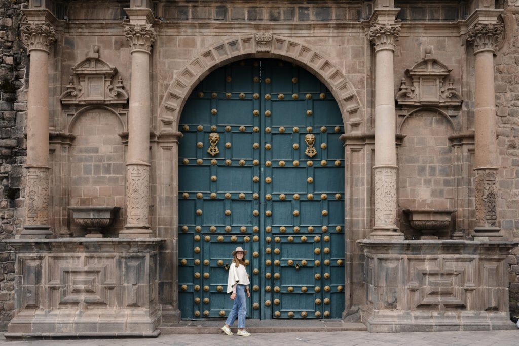 girl walking past old door in Cusco’s Historical Center