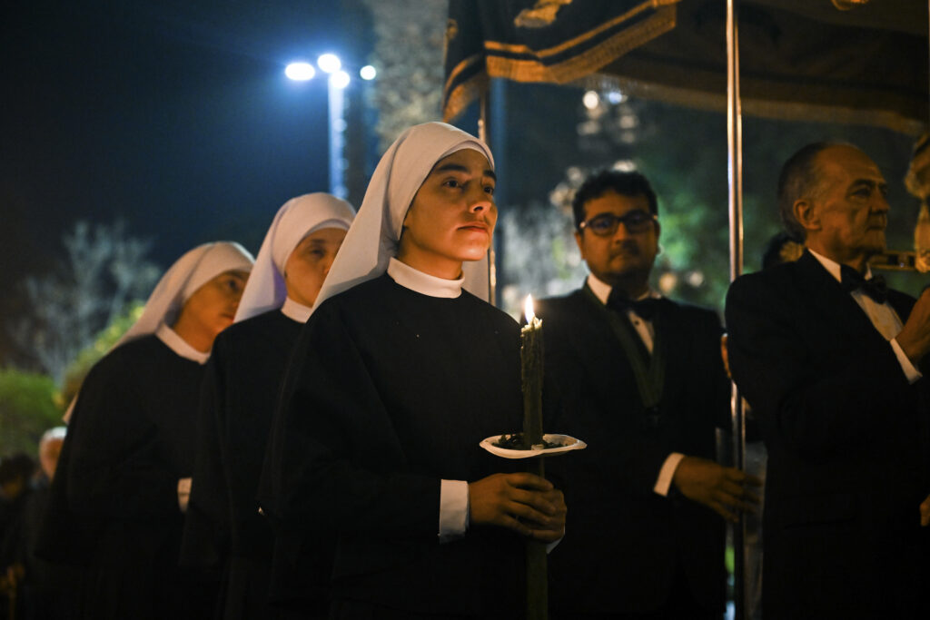 nuns walking with candles at the holy Friday procession in Arequipa, Peru 