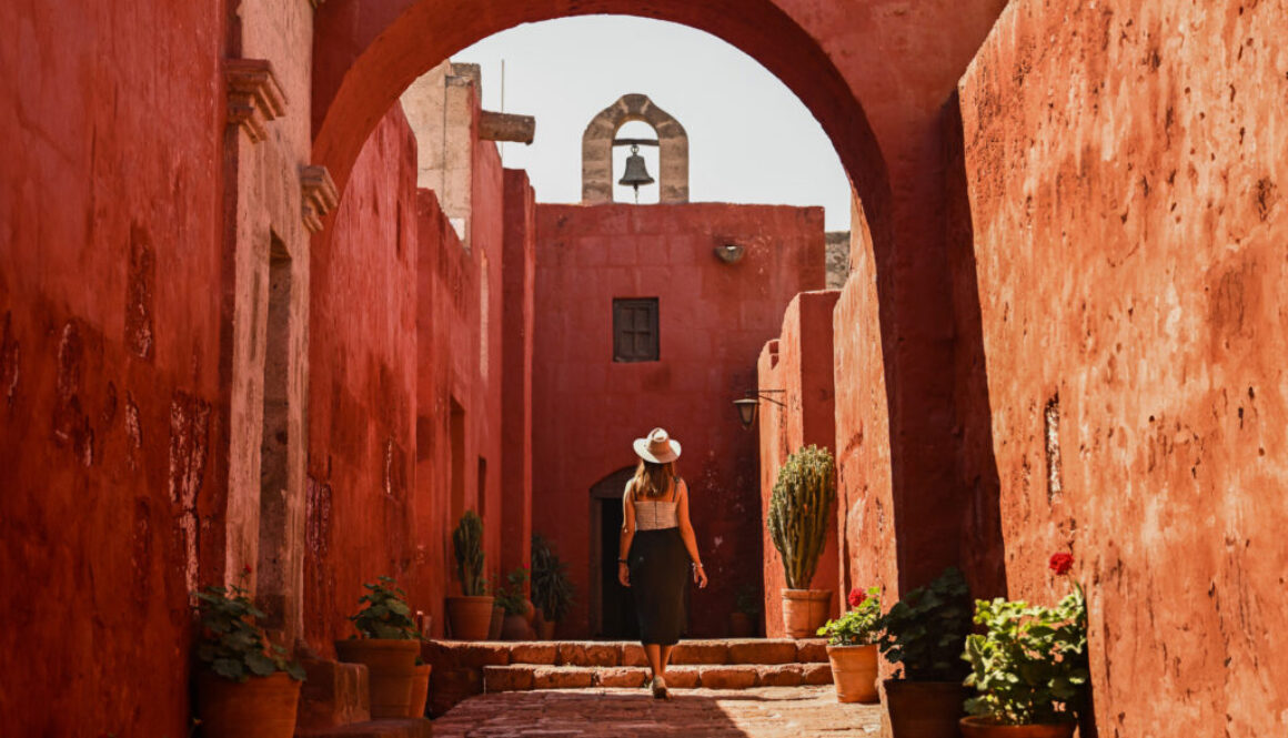 Girl walking underneath arch in Santa Catalina Monastery in Arequipa, Peru