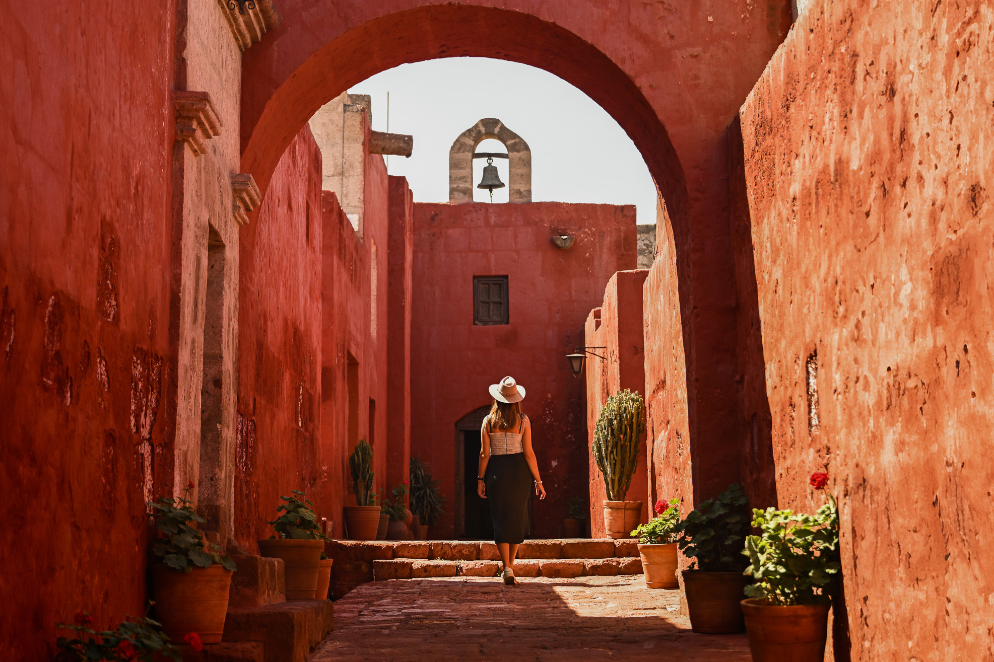 Girl walking underneath arch in Santa Catalina Monastery in Arequipa, Peru