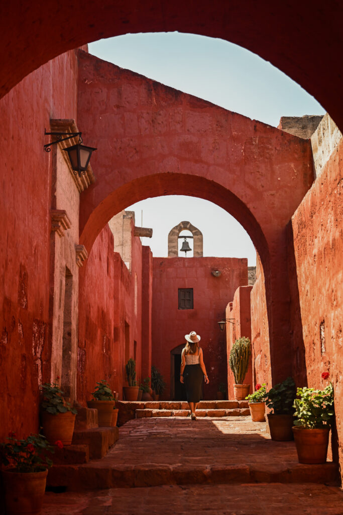 Girl walking underneath arches in Santa Catalina Monastery Arequipa, Peru