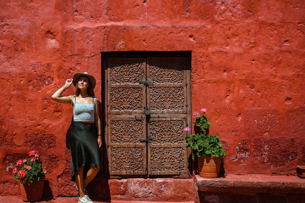 girl posing against red wall in Santa Catalina Monastery in Arequipa , Peru