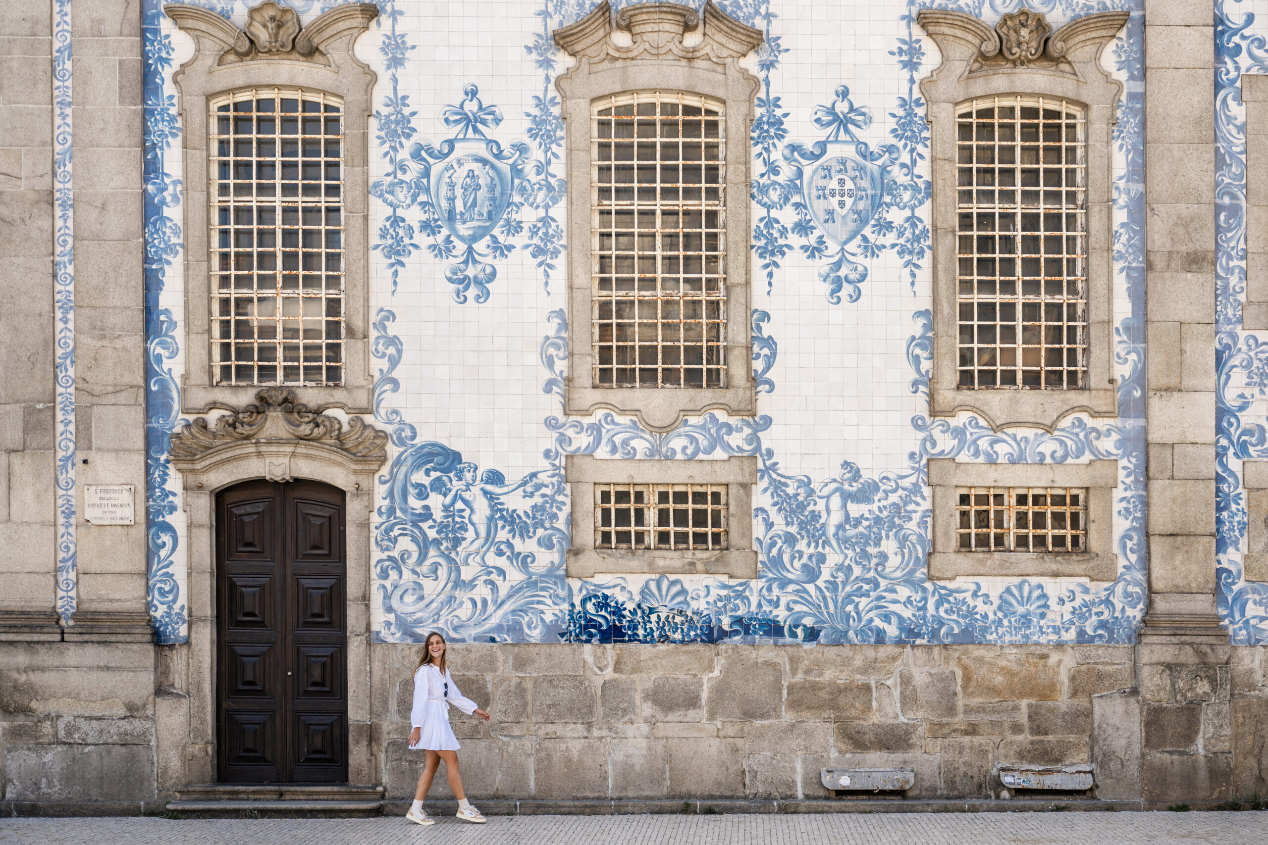 Girls walking past Azulejo tiles of the Igreja do Carmo in Porto, Portugal