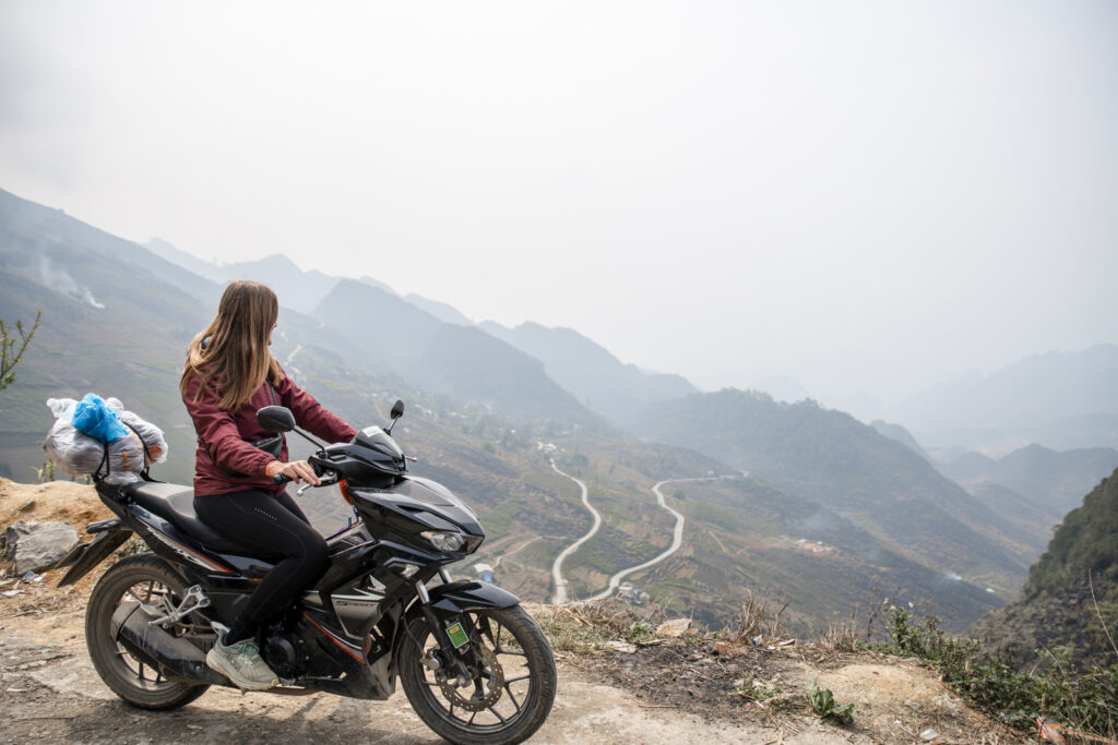 girl on motorcycle overlooking valley on Ha Gian Loop, Vietnam